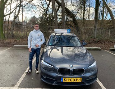 Geslaagde leerling Noah bij de lesauto van Autorijschool JongeLeeuw